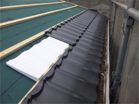 新規屋根材張り開始、断熱材を敷き込みながら張っていきます